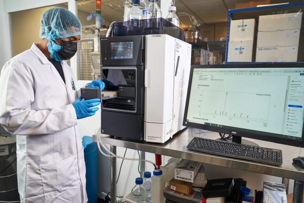 Staff at LH Botanicals in full protective lab outfit using multiple lab machines during research and lab reports